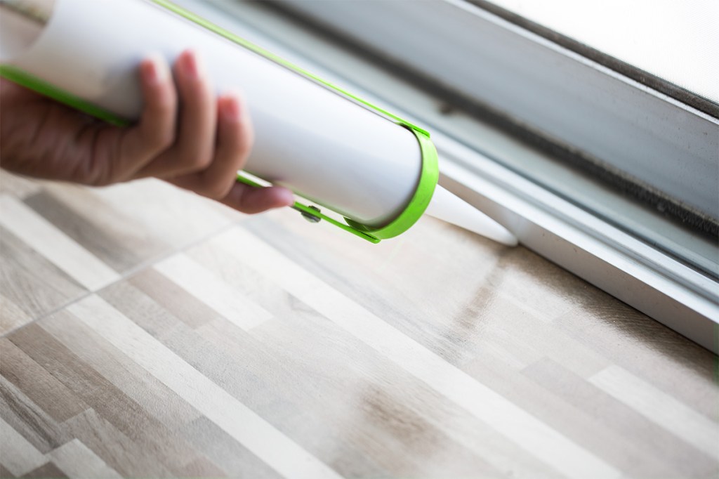 property manager doing year-end maintenance with a caulk gun