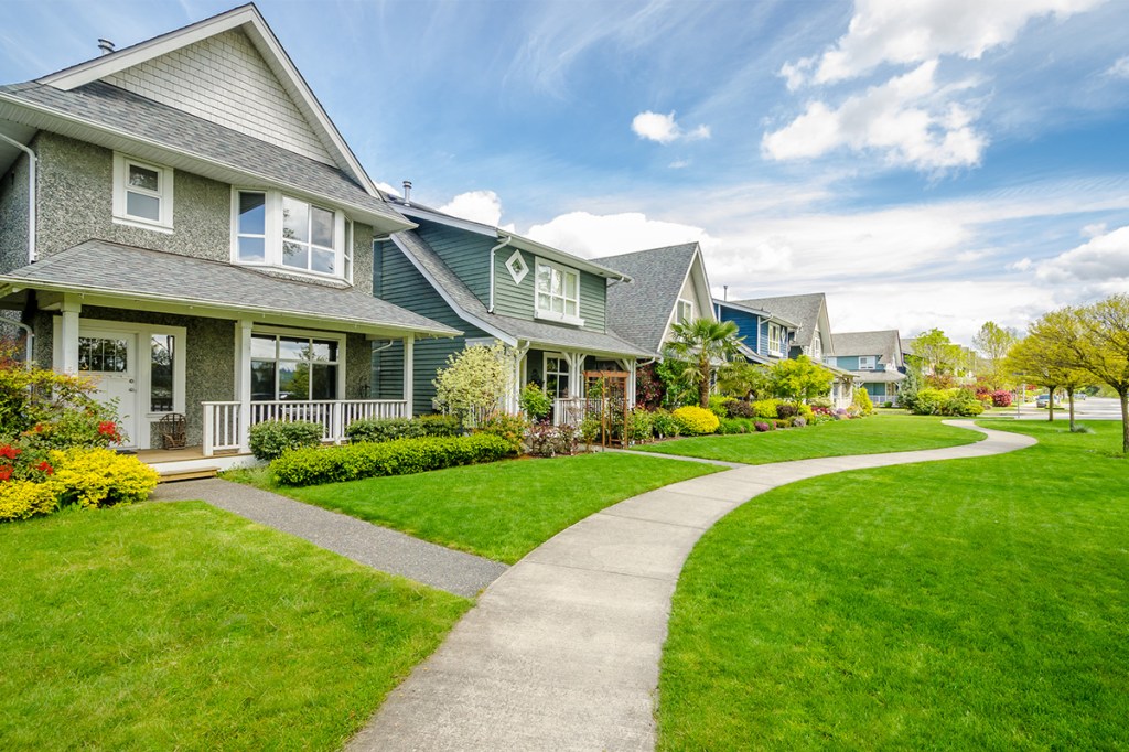 a block of single family housing with green grass out front