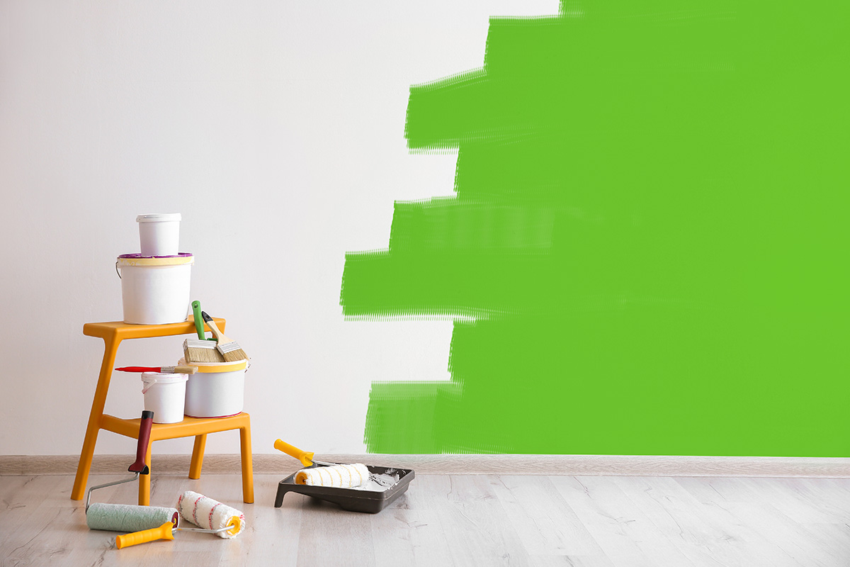 half painted accent wall with ladder and paint buckets