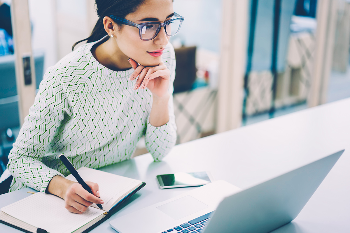 brunette woman watching yardi breeze webinars on a laptop