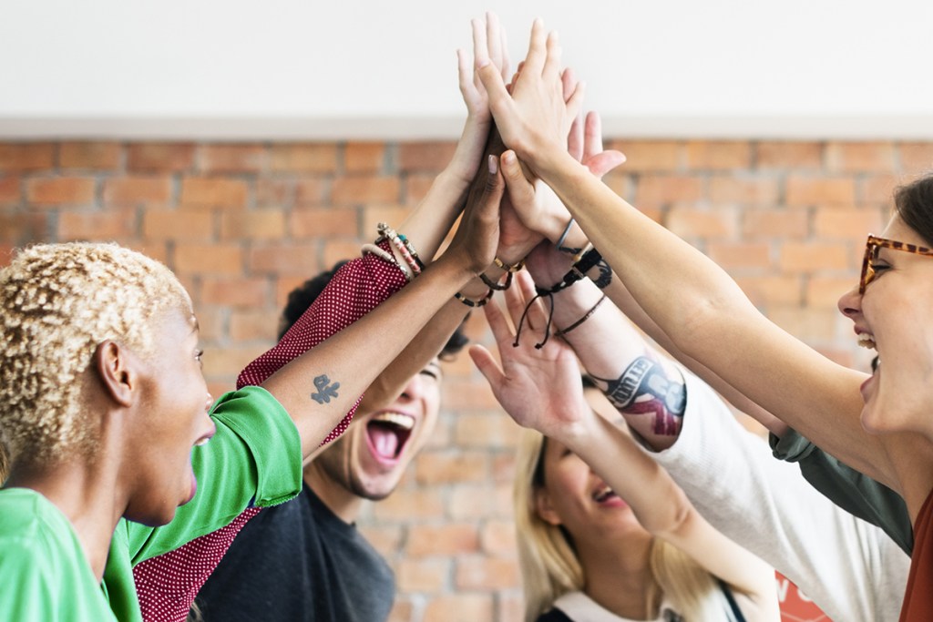 Members of a strong property management team giving a group high-five