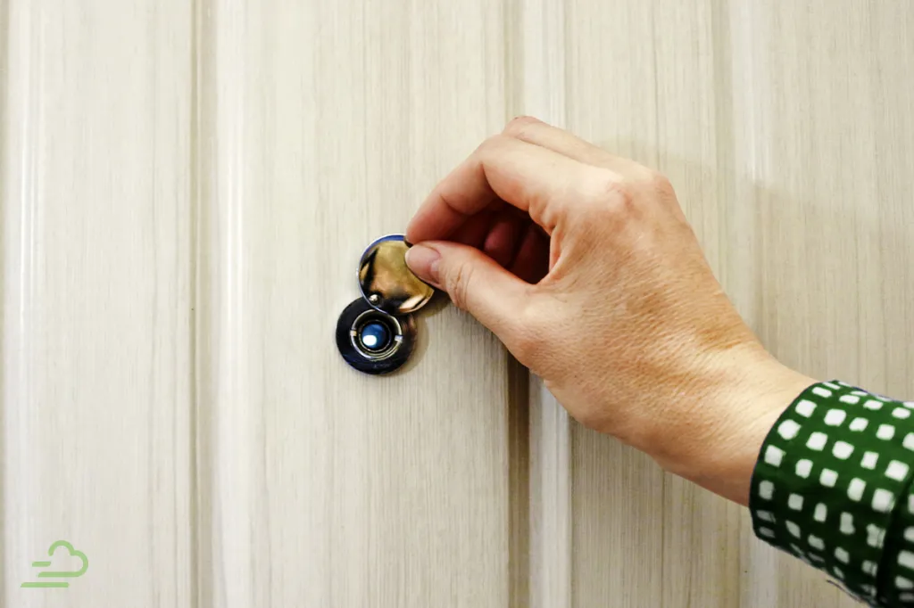 Resident checks the peep hole and enjoys extra safety thanks to her property manager