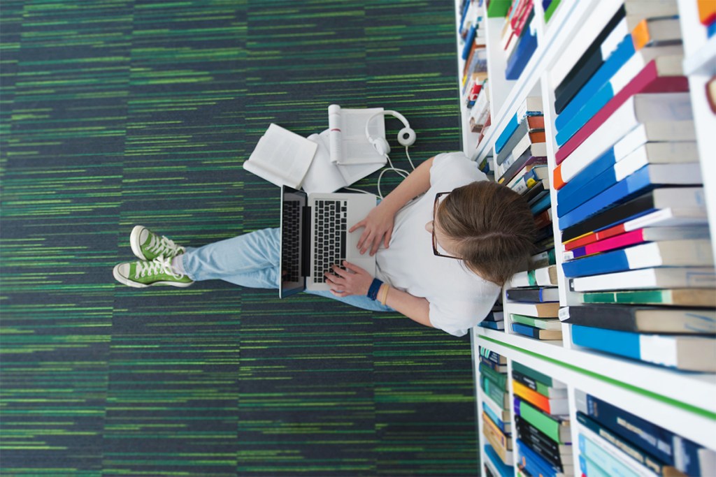 Property manager in a library reading about the history of property management