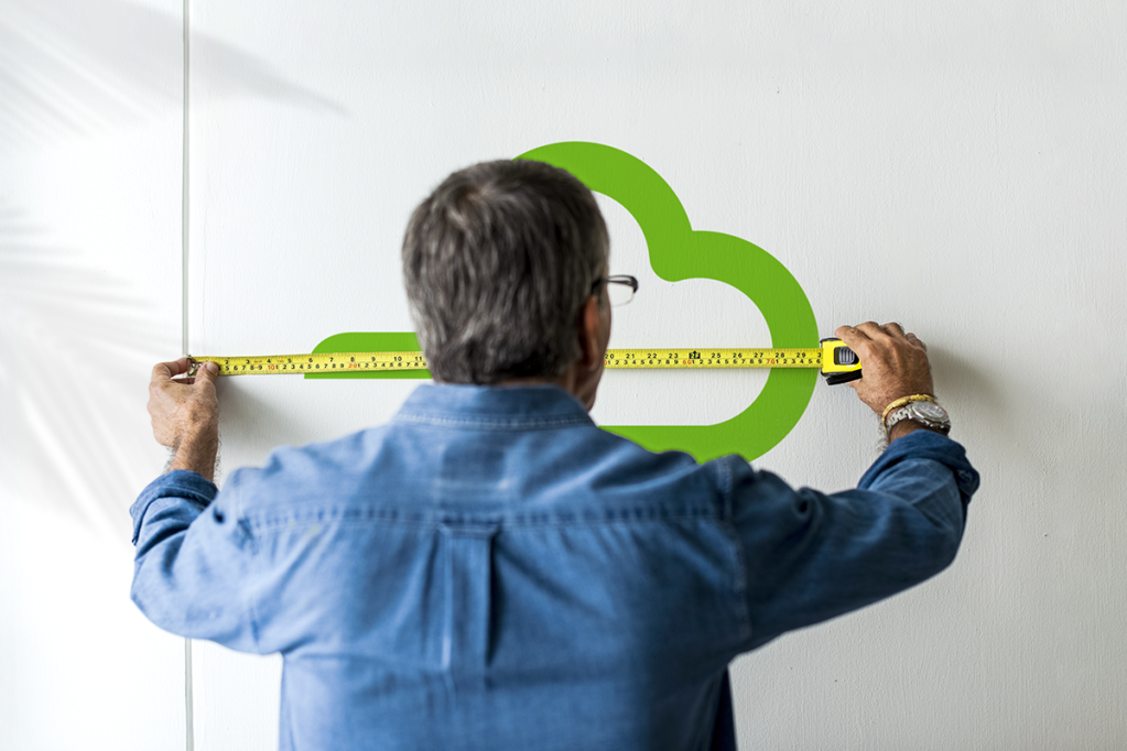 Man measuring the Yardi Breeze logo on a wall