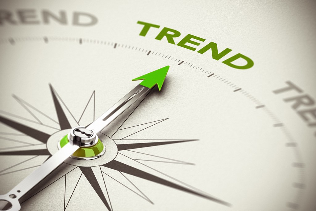 A compass needle pointing to the word "trend"