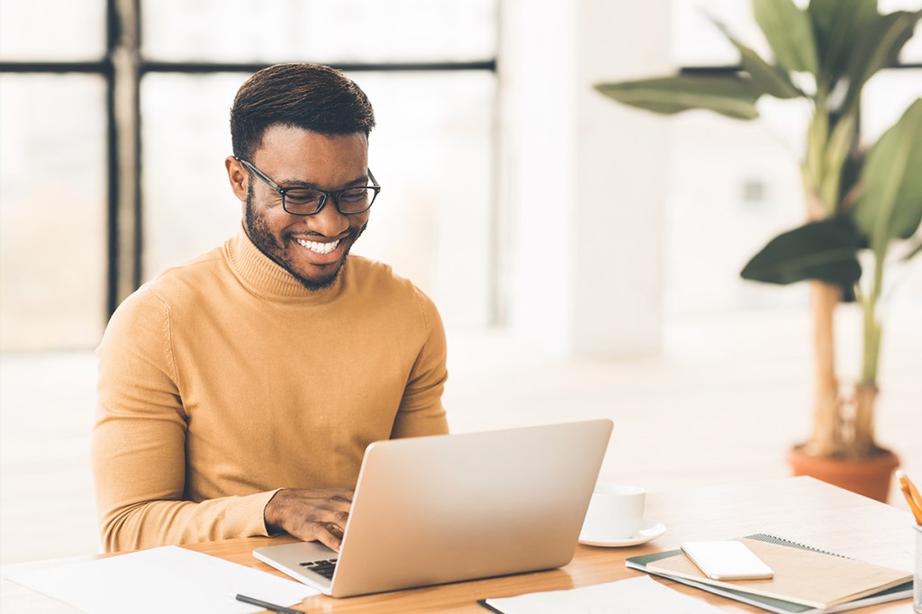 Man using a computer, reviewing his property marketing website