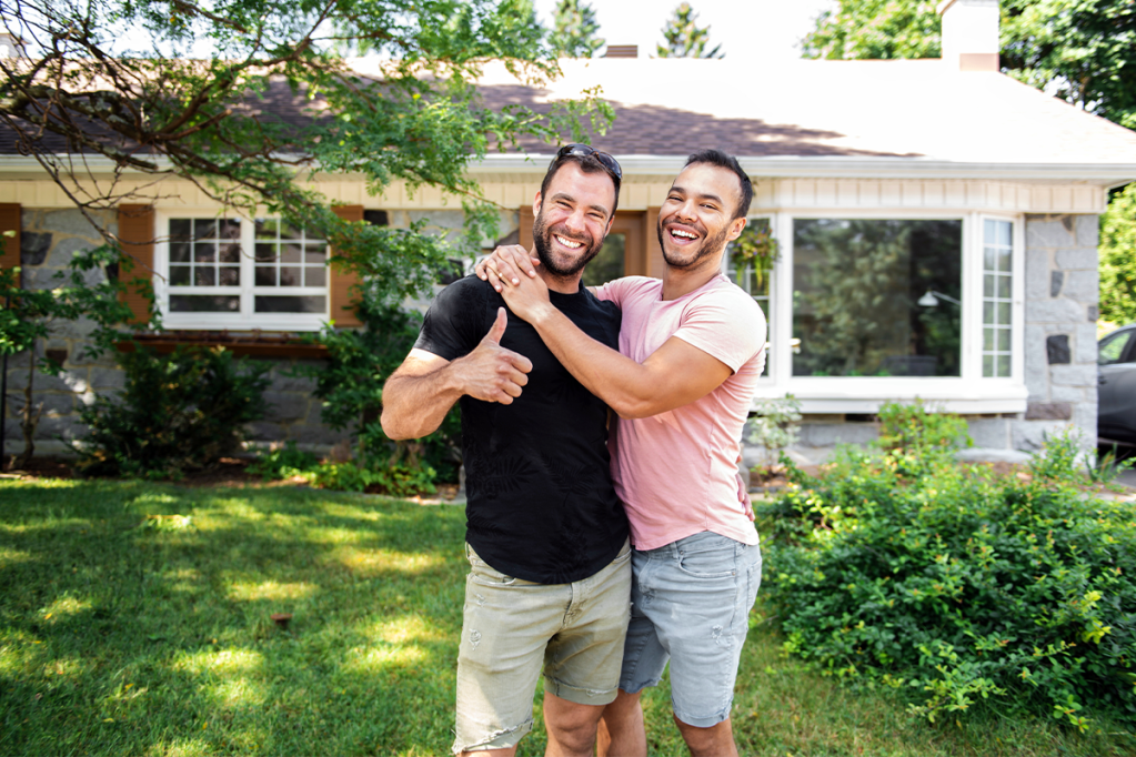 Two men celebrating fair housing digital compliance with a hug
