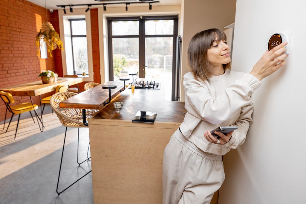 Smiling resident adjusting her smart thermostat