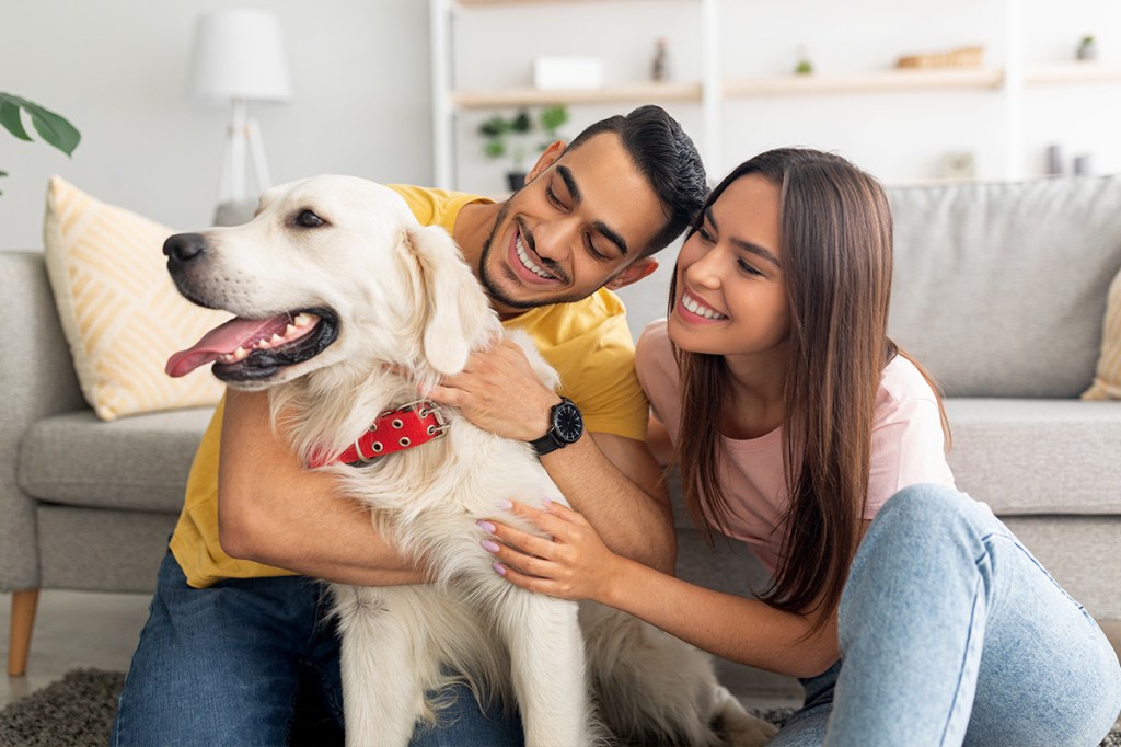 Two residents with a dog in their pet-friendly apartment
