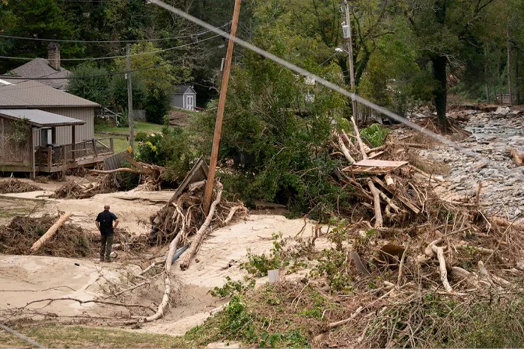 Image of man standing in wreckage of Hurricane Helene