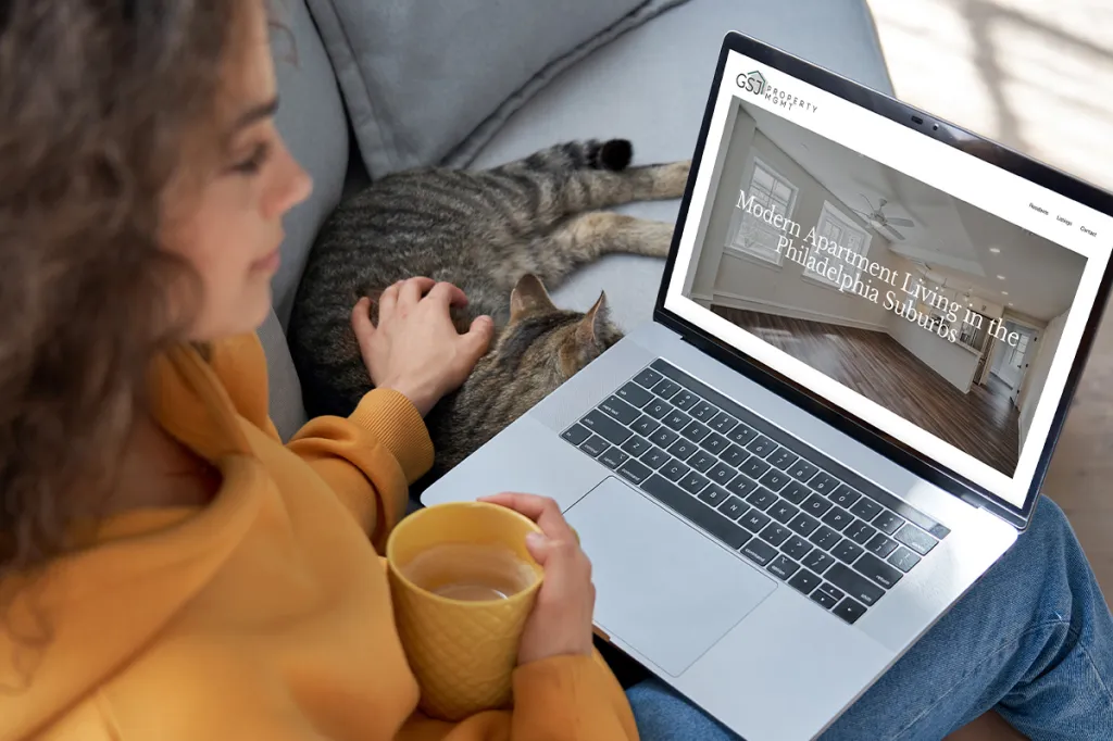 What RentCafe websites can do for you: image of woman on laptop, next to sleeping cat