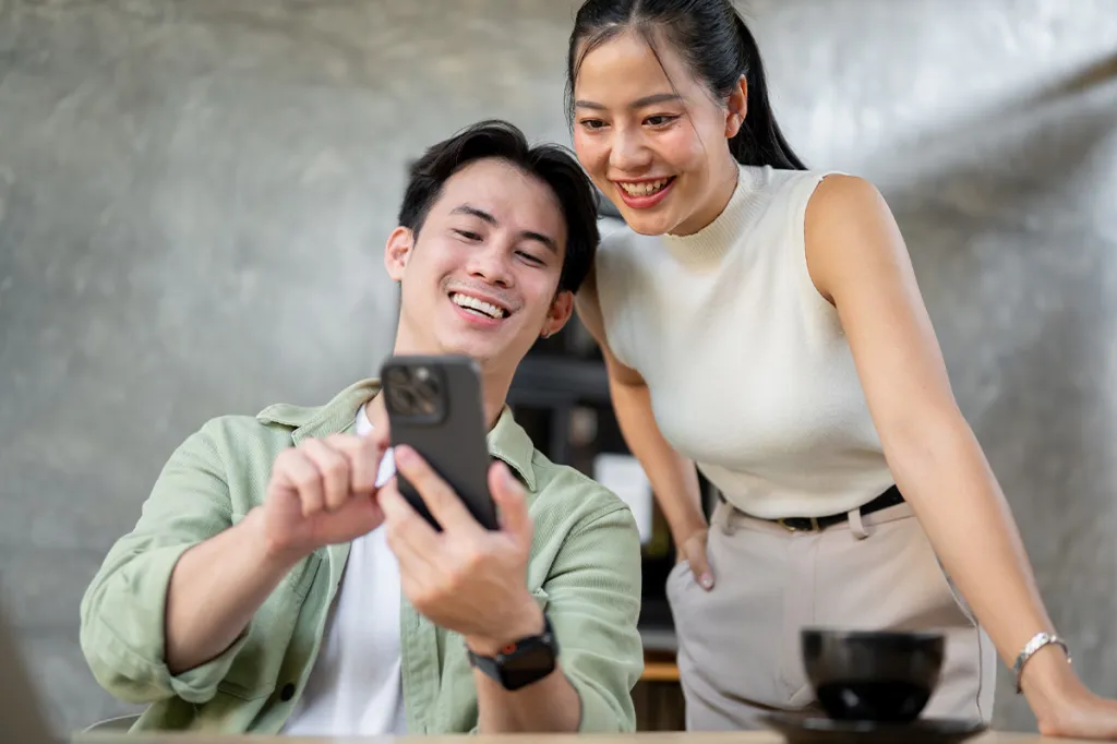 Two renters looking at their simple lease agreement template on a phone