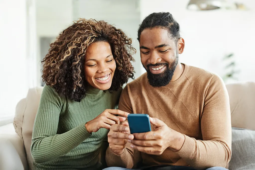 Couple looking at smartphone and smiling
