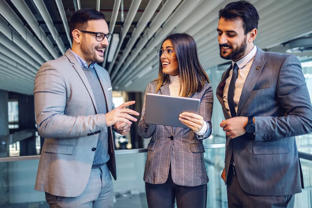 Three professionals looking at a laptop together