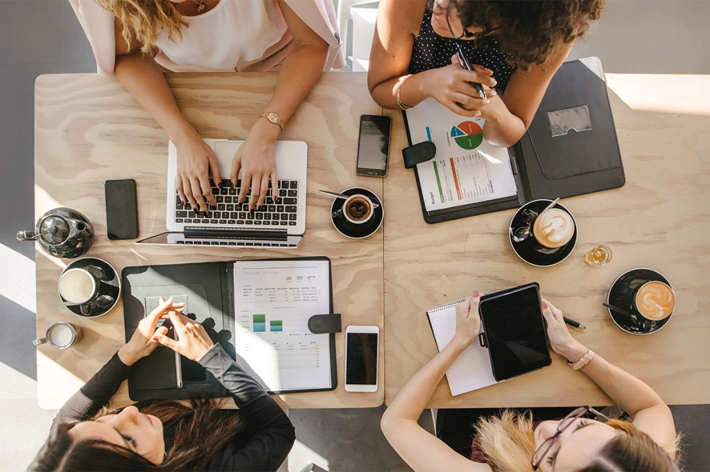 Overhead shot of four people working on laptops