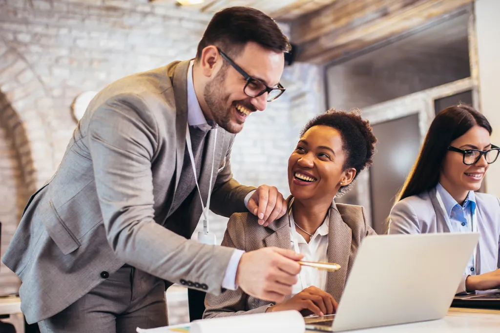 Three professionals smiling together at the office